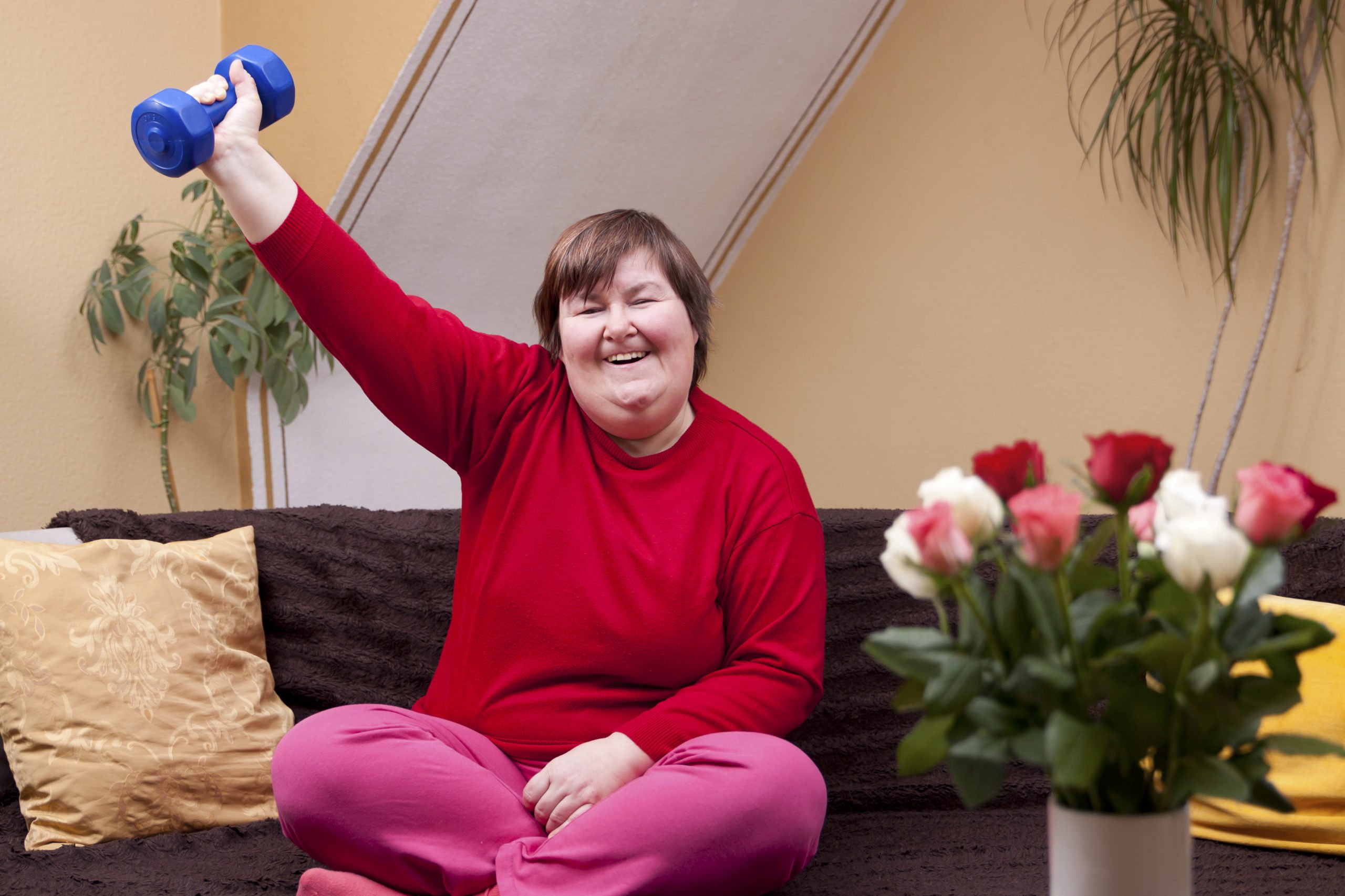 image of smiling woman with down syndrome lifting hand held weight