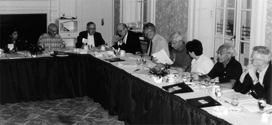 several people sitting at a table in a board meeting